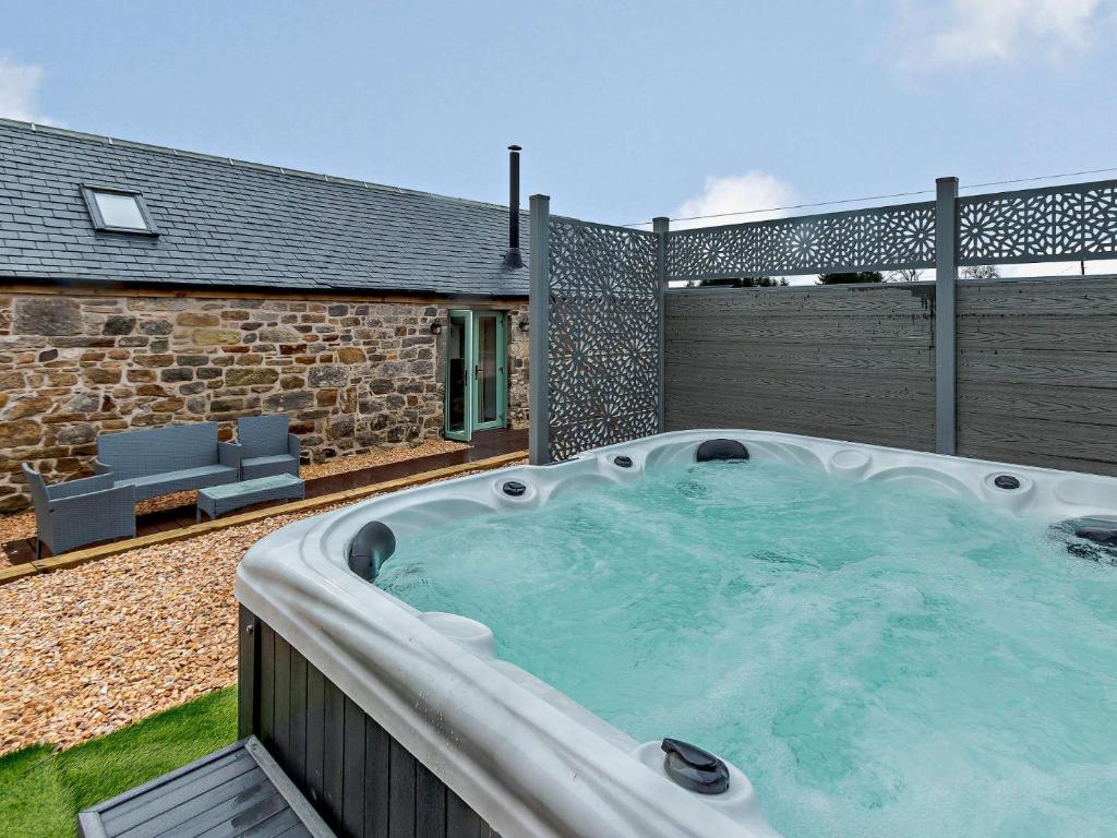 una bañera de hidromasaje en el patio trasero de una casa en 3 Bed in Lanark 81079, en Forth