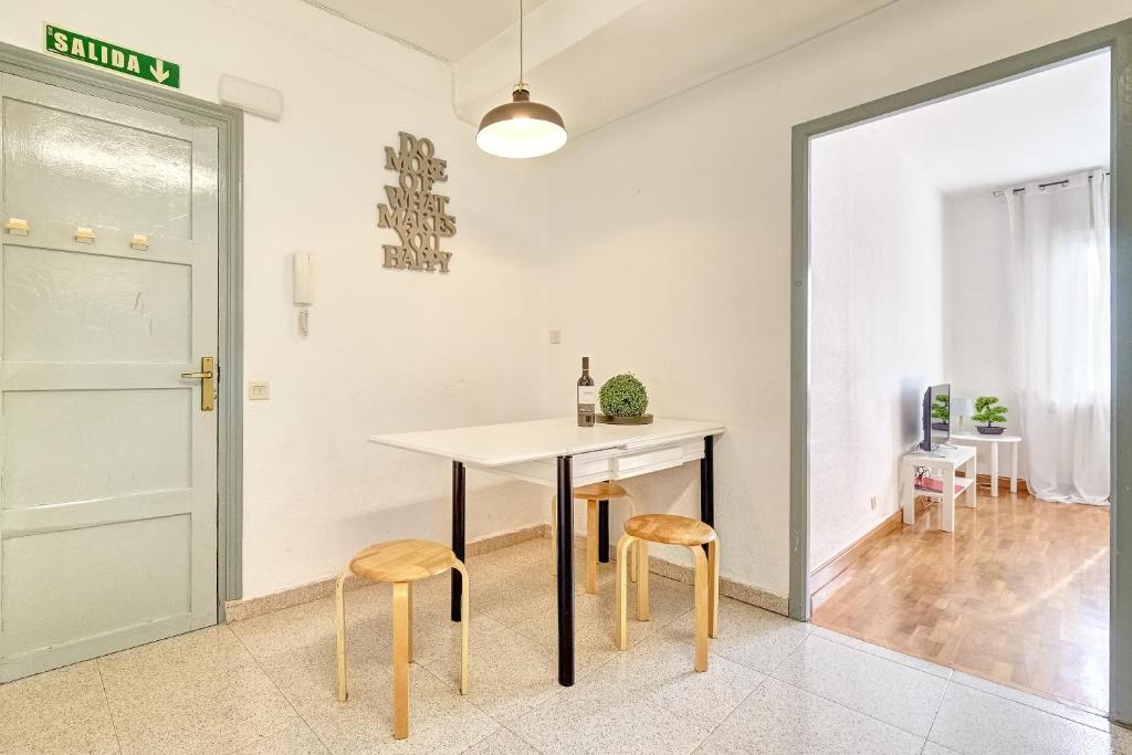 a dining room with a table and two stools at Mesón Pamplona by Clabao in Pamplona