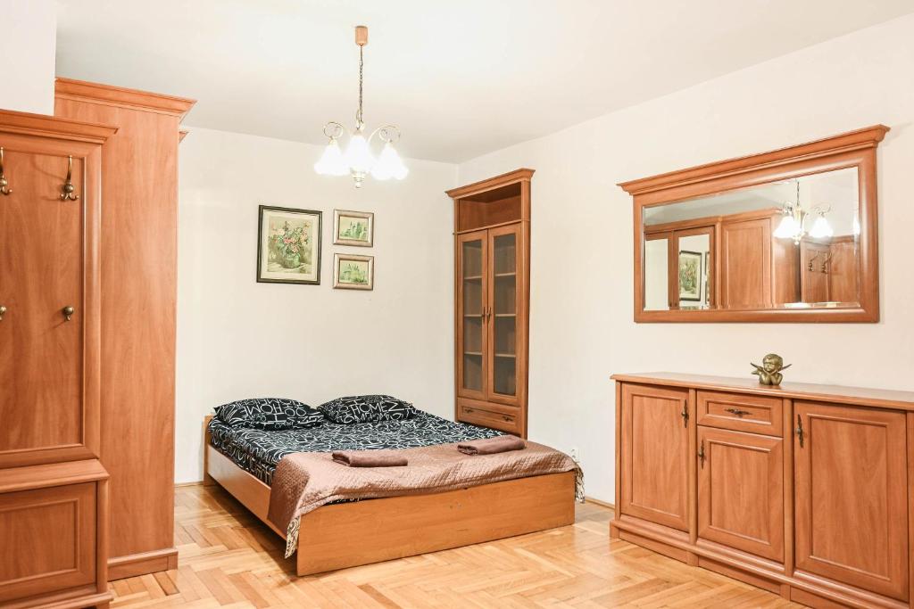 a bedroom with a bed and a dresser at D&A Apartments Szewska in Krakow