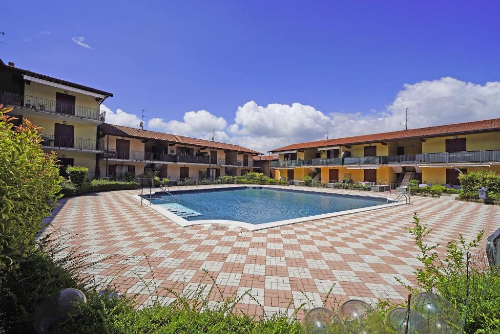 ein großer Pool in einem Innenhof mit Gebäuden in der Unterkunft Appartamento Magenta - Gardagate in Moniga