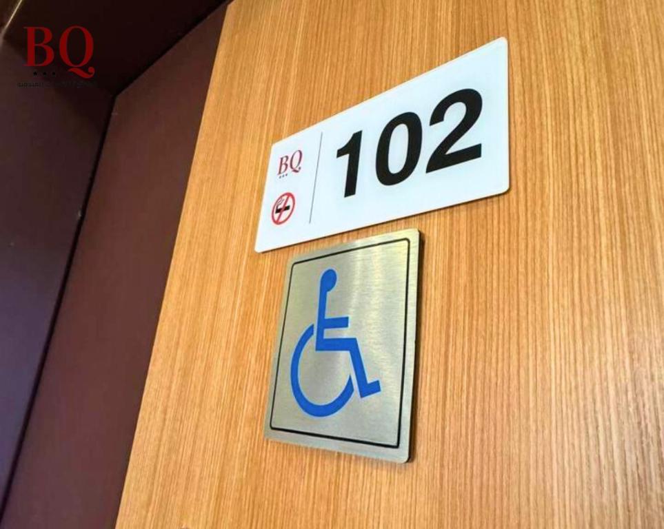 un signo de minusvalía en una puerta con un signo de minusvalía en البندقية للخدمات الفندقية BQ HOTEL SUITES, en Buraidah
