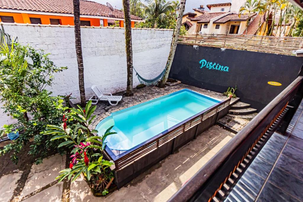 uma piscina exterior com um baloiço num resort em Pousada Maré Alta - MARESIAS em Maresias