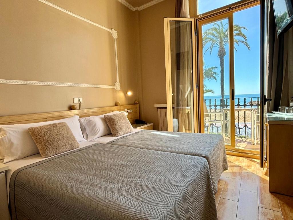 a bedroom with a bed with a view of the ocean at Hotel Celimar in Sitges