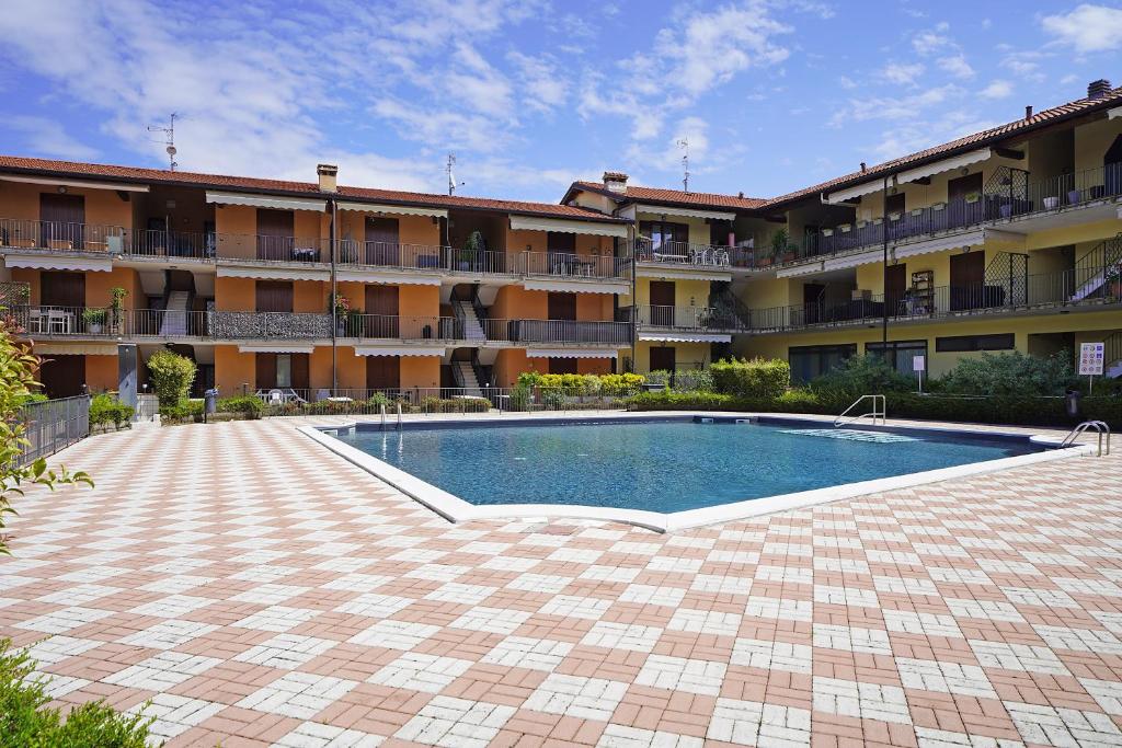 una piscina di fronte a un edificio di Appartamento Chiaretto - Gardagate a Moniga