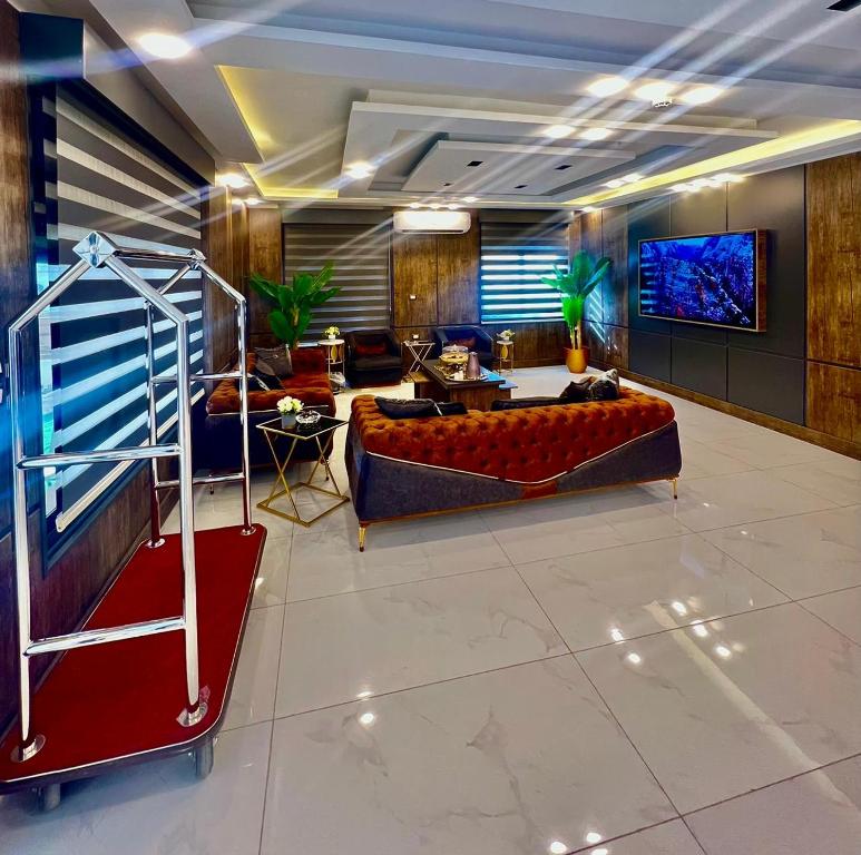 رويال جروب اربد Royal Group Hotel في إربد: غرفة معيشة مع أريكة وتلفزيون بشاشة مسطحة