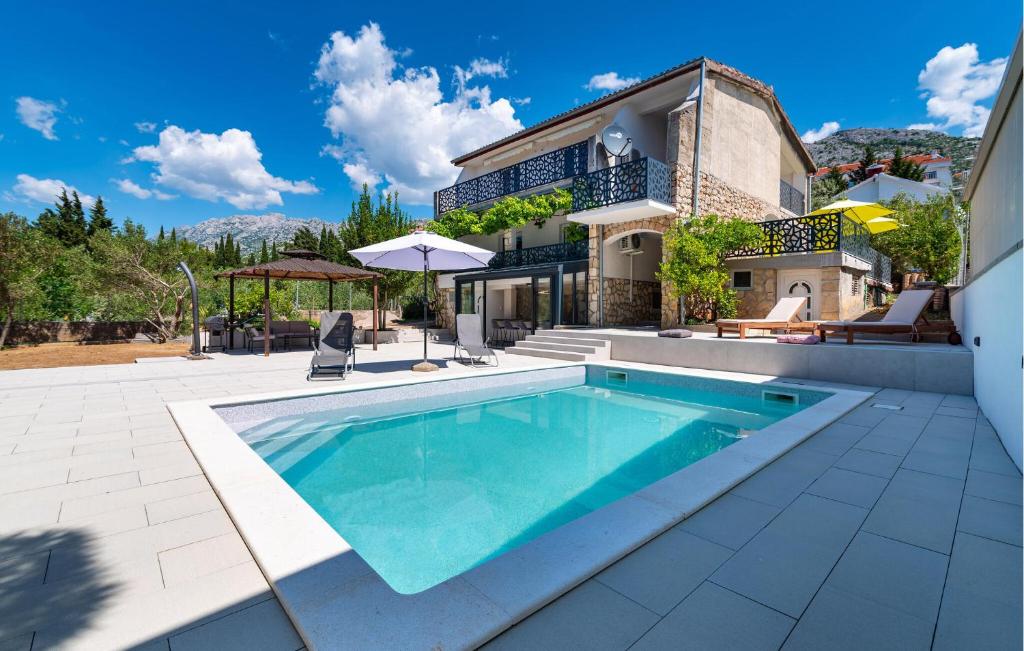 a swimming pool in front of a house at Cozy Home In Starigrad Paklenica in Starigrad-Paklenica