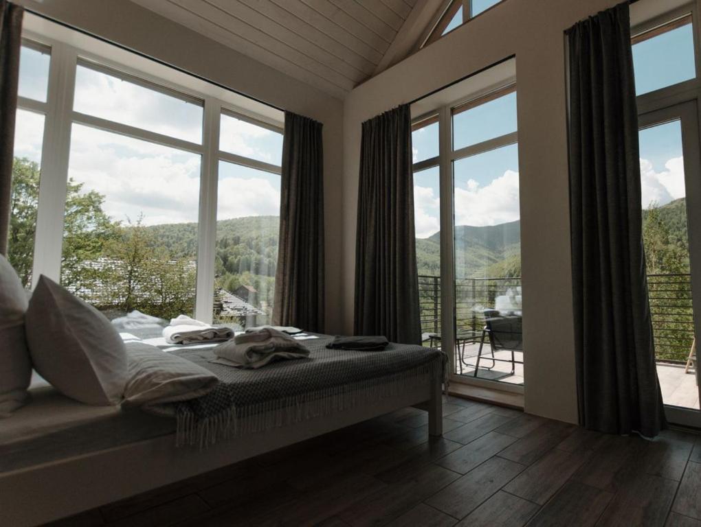 a bedroom with a bed and a large window at Apart-hotel Vershina in Yaremche