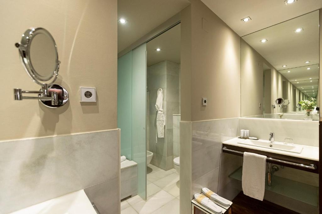 a bathroom with a shower and a sink and a mirror at Hospes Amérigo, Alicante, a Member of Design Hotels in Alicante