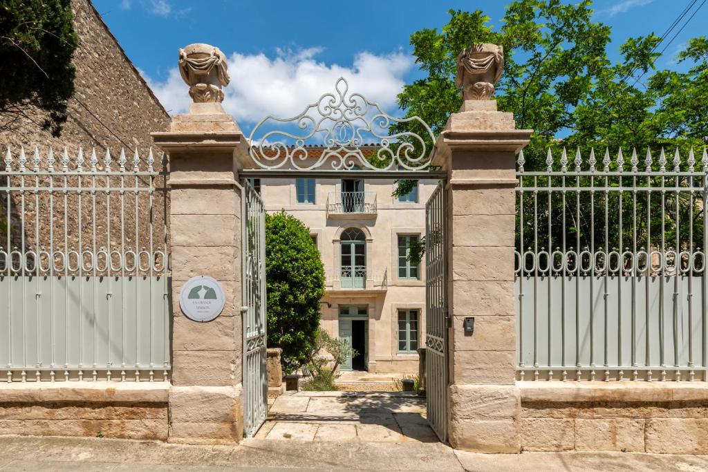 una puerta de entrada a una casa con una valla blanca en La Grande Maison Chambres d'Hôtes en Peyriac-de-Mer