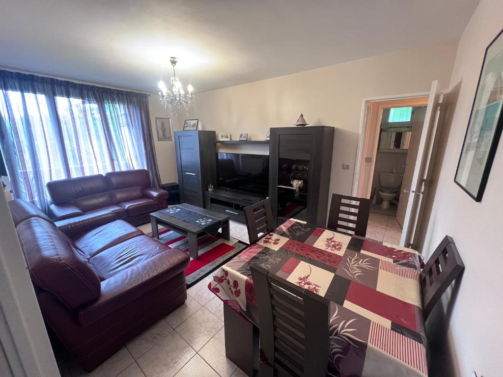 un salon avec une table et un canapé dans l'établissement Appartement vu sur Seine, à Épinay-sur-Seine