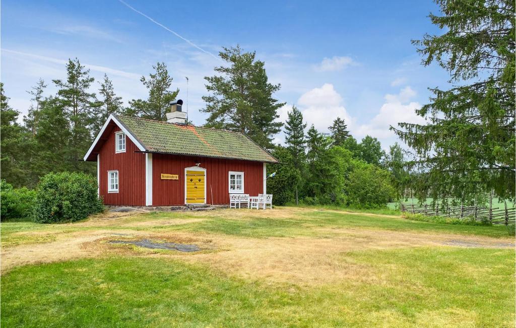 une grange rouge avec une porte jaune dans un champ dans l'établissement Beautiful Home In Valdemarsvik With Sauna, à Valdemarsvik