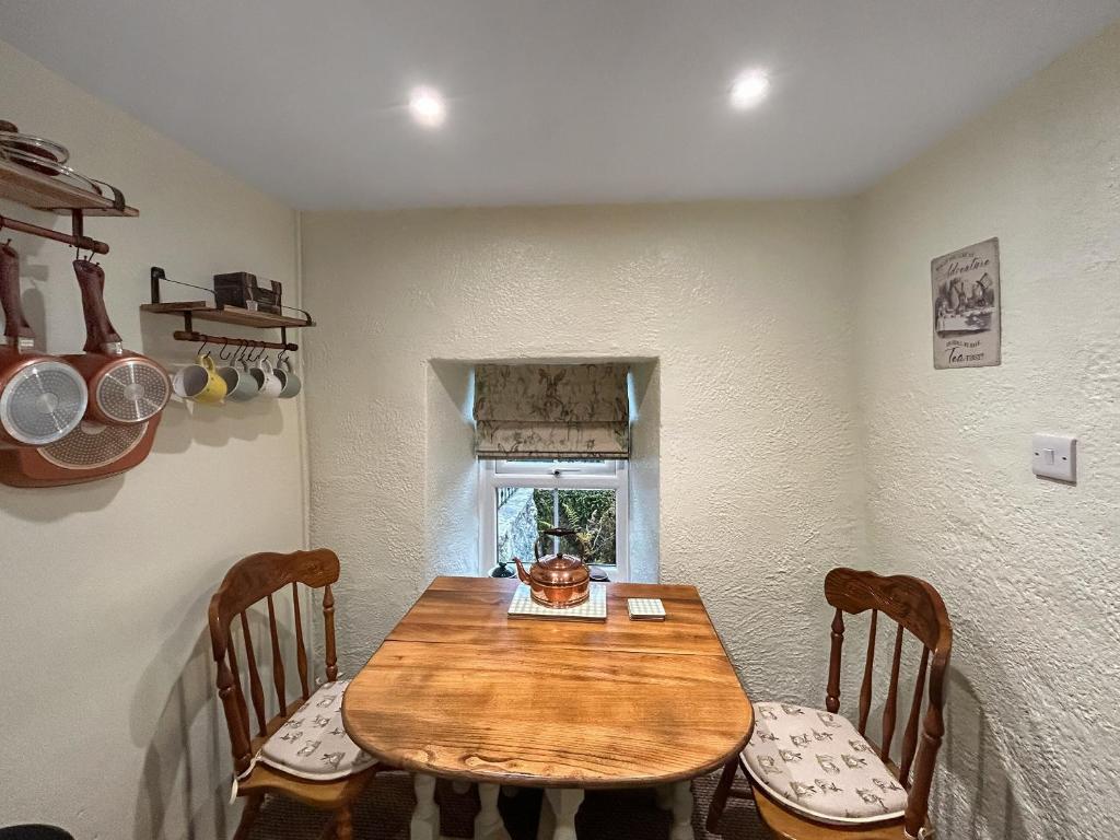 een eetkamer met een houten tafel en stoelen bij Lyndene Cottage in Moel-tryfan