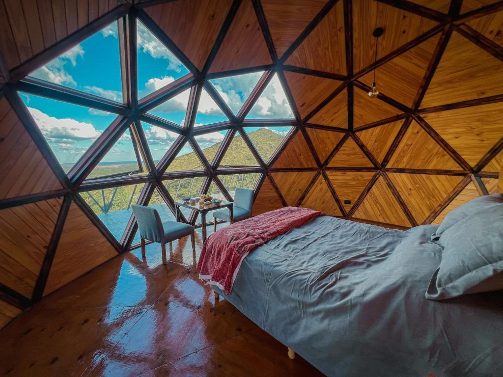 a room with a bed and a large window at Domos Zen San Luis in Estancia Grande