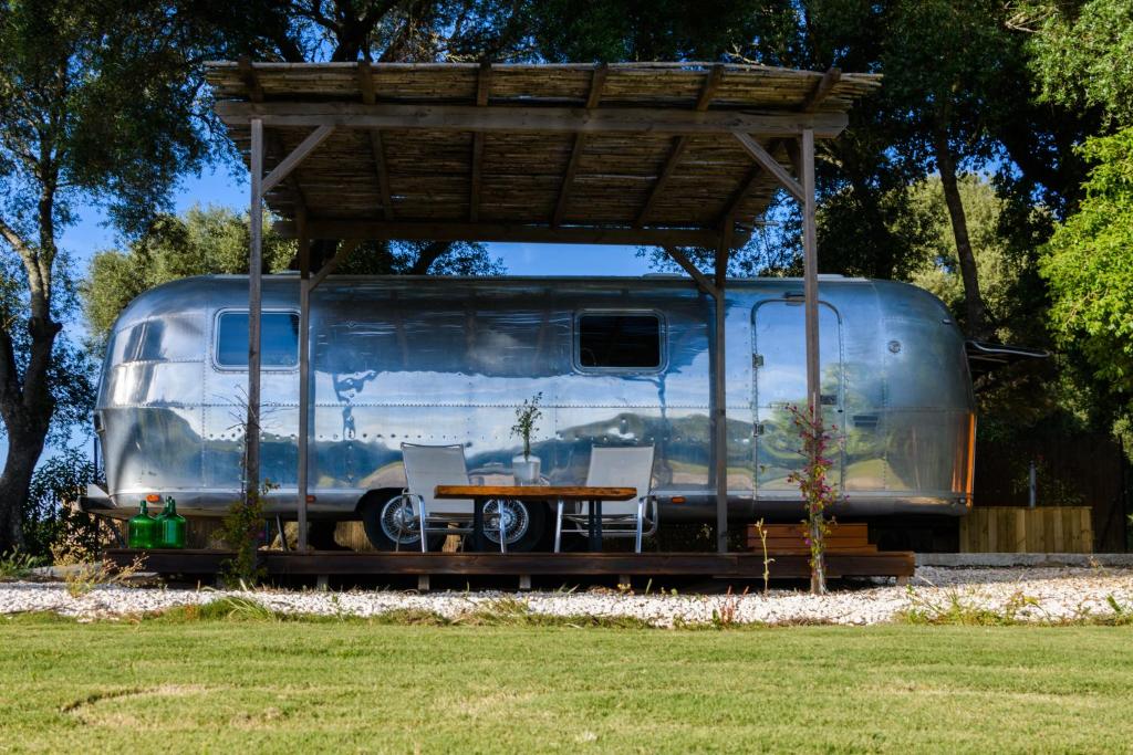 a silver trailer with a table and chairs under a canopy at Nomaddicts in Cádiz