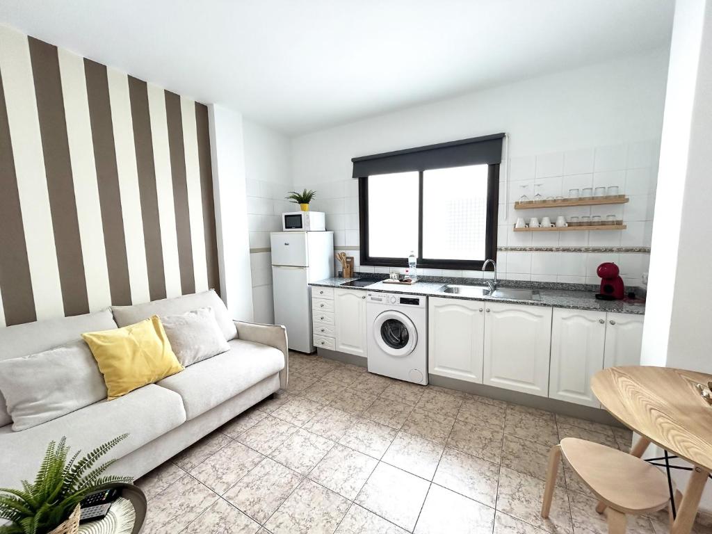 uma sala de estar com um sofá e uma cozinha em Mahostly Apartamento Comillas SH em Arrecife