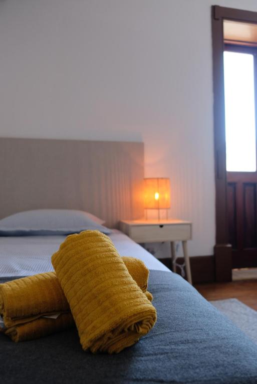 a yellow pillow on a bed in a bedroom at Yellow Inn Aveiro in Aveiro