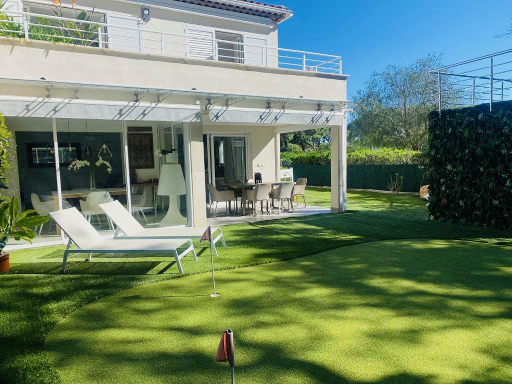 d'une terrasse avec des meubles blancs sur une pelouse. dans l'établissement Maison de Vacance La Belle, à Sainte-Maxime