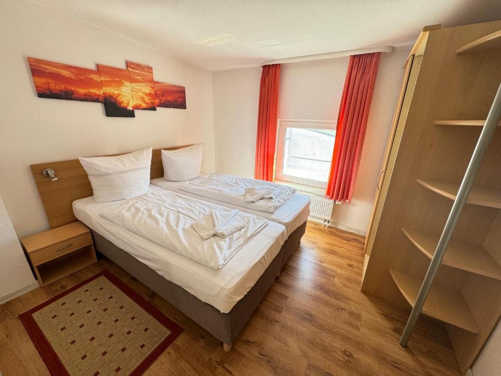 ein kleines Schlafzimmer mit einem Bett und einem Fenster in der Unterkunft Aalreuse in Rostock