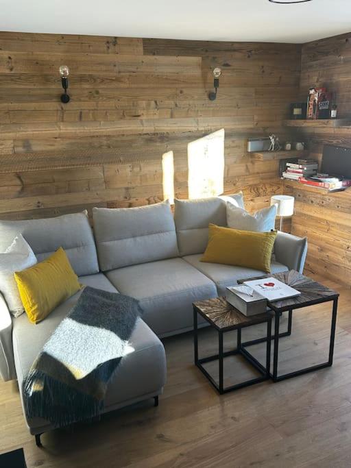 un salon avec un canapé et une table dans l'établissement Appartement á Megève, à Demi-Quartier