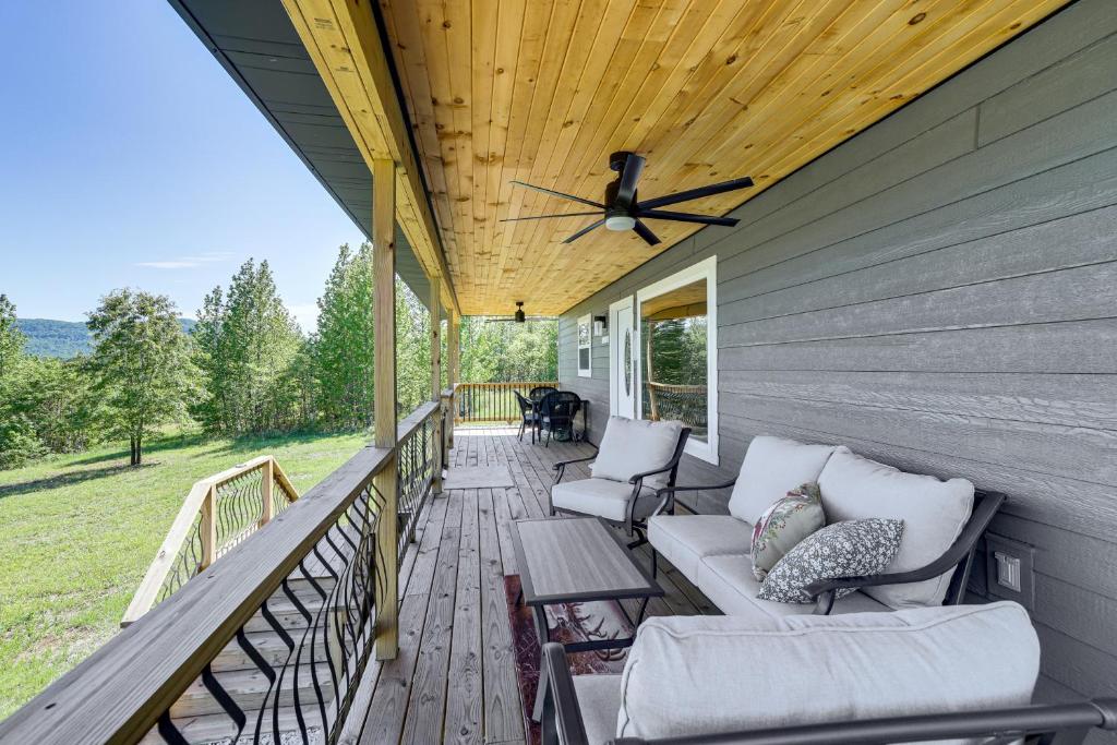 a porch with couches and a ceiling fan at Arkansas Retreat with Deck, Fire Pit and Mtn Views! in Jasper