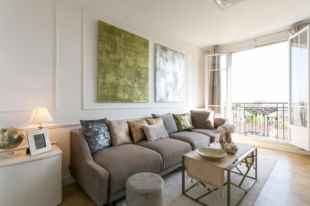 un salon avec un canapé et une table dans l'établissement Appartement de charme près de La Défense, à Colombes