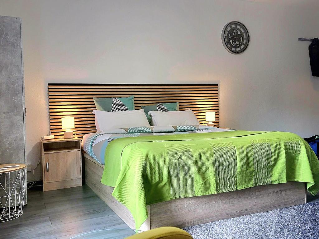 a bedroom with a large bed with a green blanket at Happy studio 64 St louis in Saint-Louis