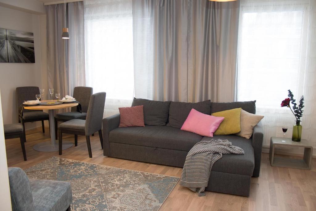 ヘルシンキにあるAurinkolahti cosy apartment with warm parkingのカラフルな枕が置かれた灰色のソファのあるリビングルーム