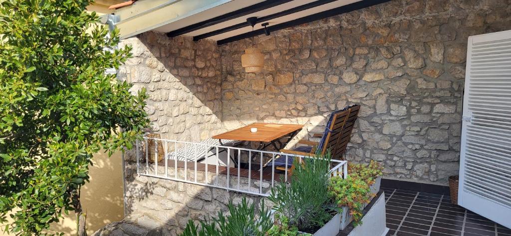 a patio with a wooden table and a stone wall at Old town STONE HOUSE OASIS in Selce