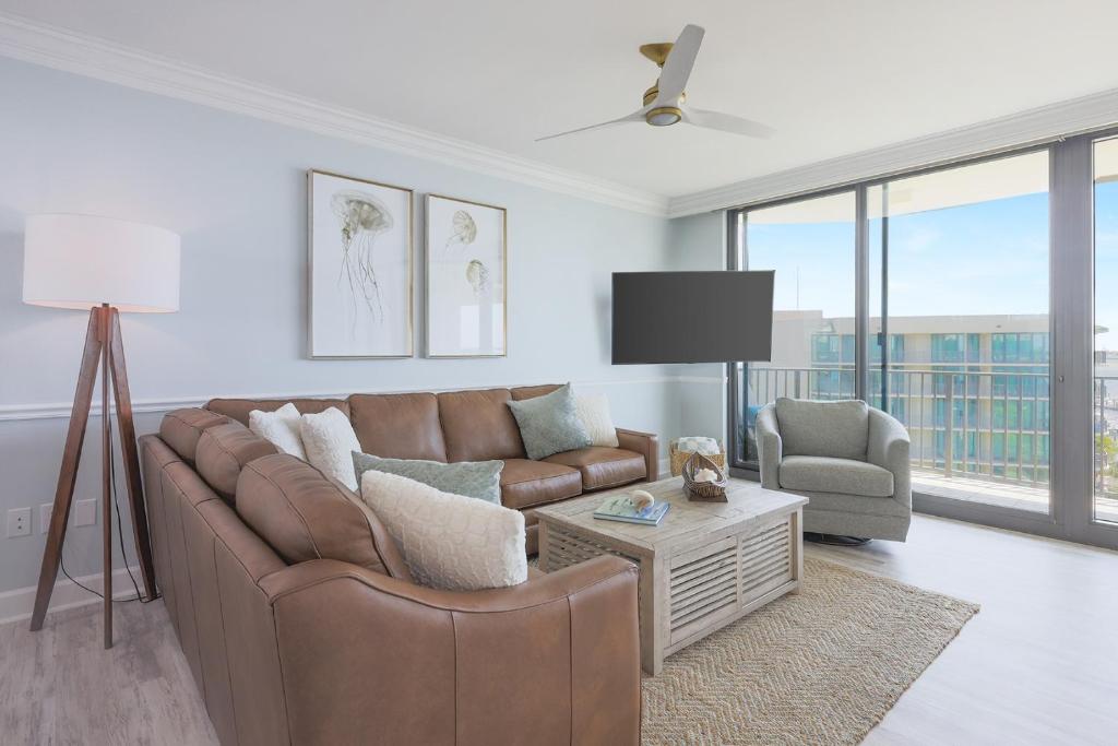 sala de estar con sofá marrón y silla en Phoenix on the Bay 1506 condo, en Orange Beach