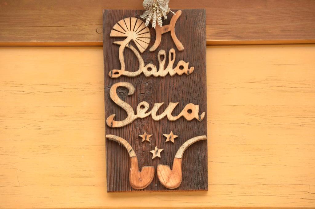 una señal que dice balala suna colgando de una pared en Hotel Dalla Serra, en Mezzana