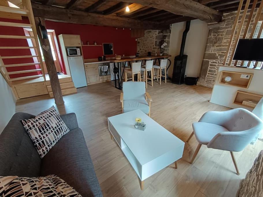 un salon avec un canapé et une table dans l'établissement Gîte de la Forêt, à Le Mesnil-Rogues