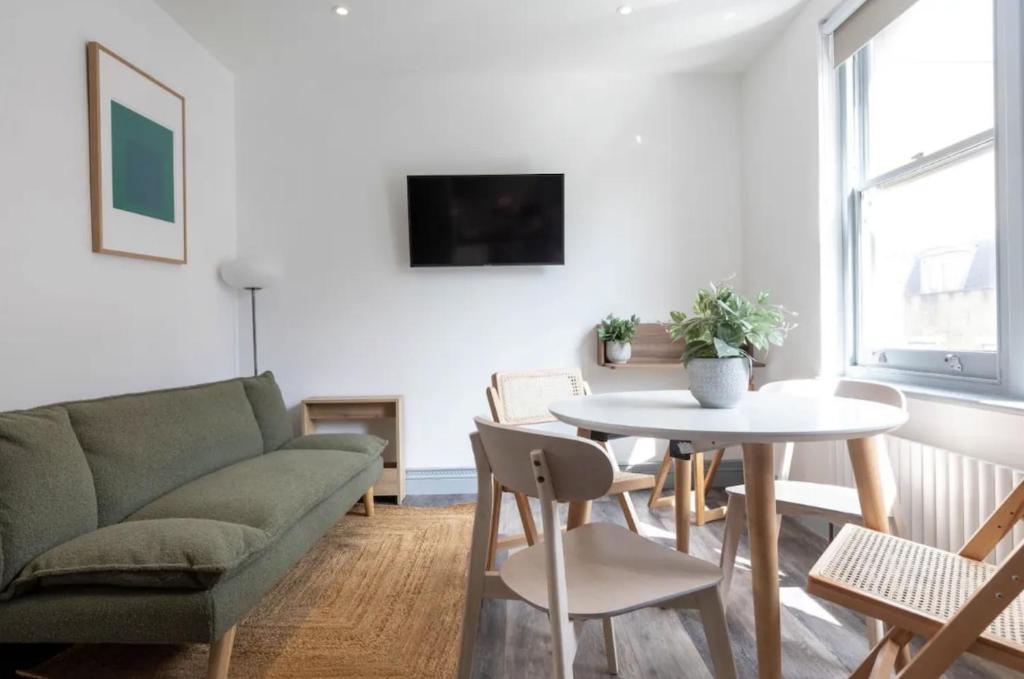 een woonkamer met een bank en een tafel bij Urban Chic: Stylish 1-Bed in the Heart of the City in Londen