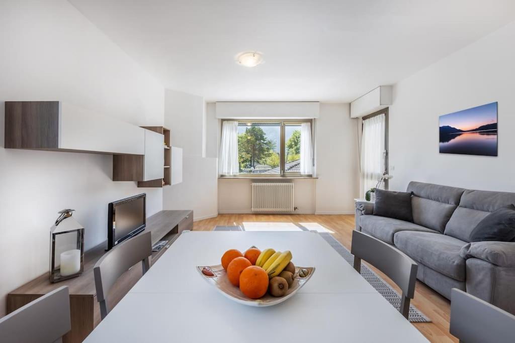 a living room with a table with a bowl of fruit on it at Riviera Beach House in Calceranica al Lago