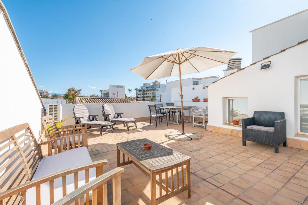 a patio with chairs and an umbrella on a roof at Can Marineta in Palma de Mallorca
