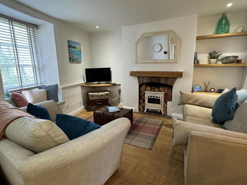 a living room with two couches and a fireplace at Rose Cottage - Central Dartmouth in Dartmouth