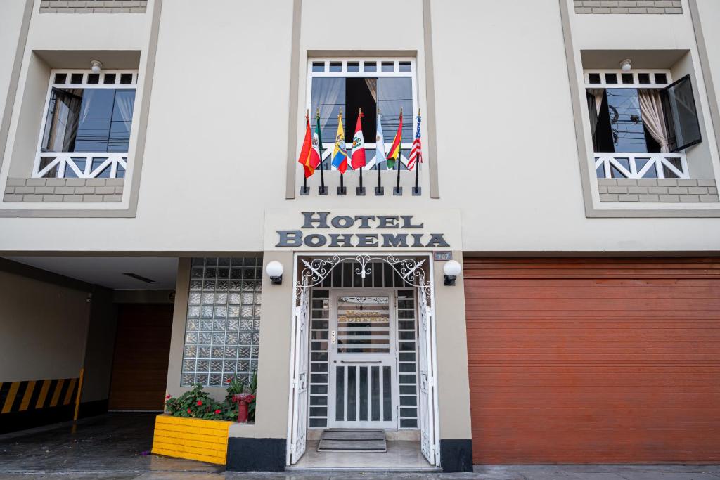 un hôtel botswana arborant des drapeaux à l'avant d'un bâtiment dans l'établissement Hotel Bohemia, à Lima