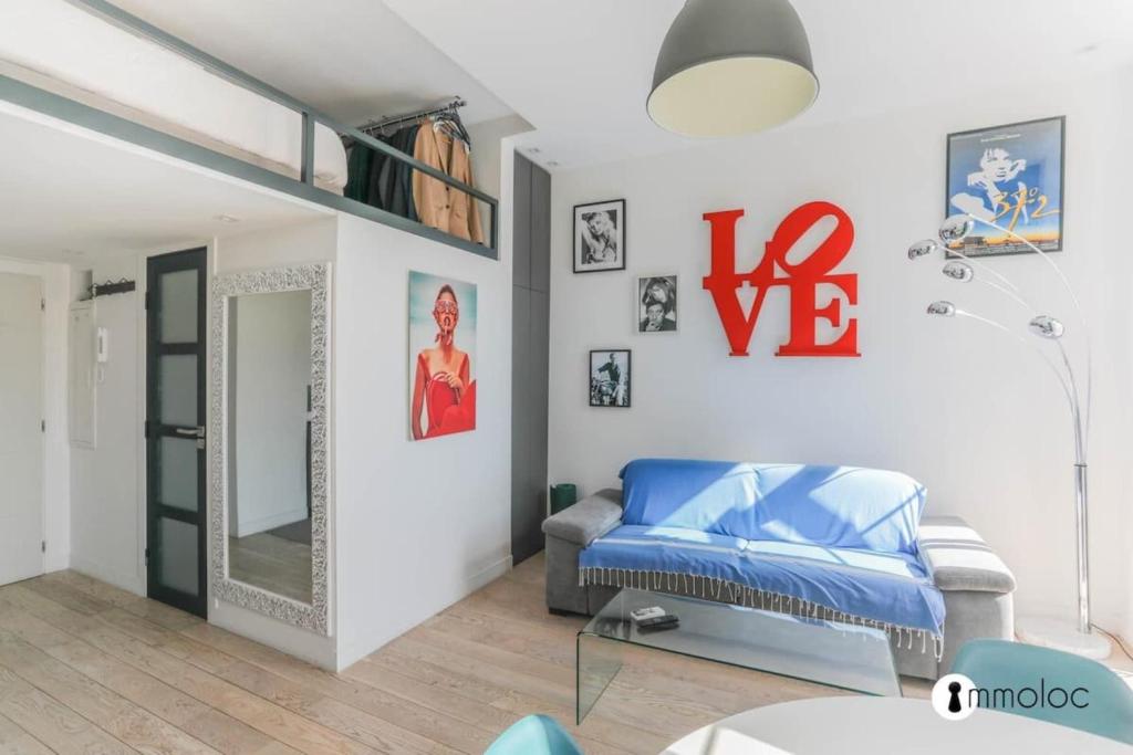 une chambre avec un lit bleu et un miroir dans l'établissement Port of Nice air conditioned studio, à Nice