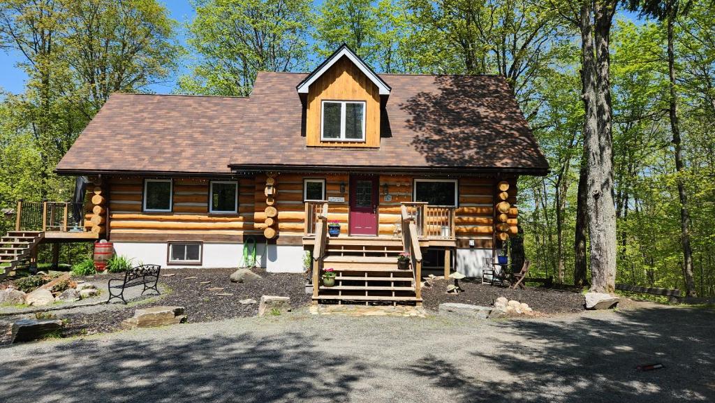 uma cabana na floresta com uma porta roxa em Bed and Breakfast Comfy & Cozy em Huntsville