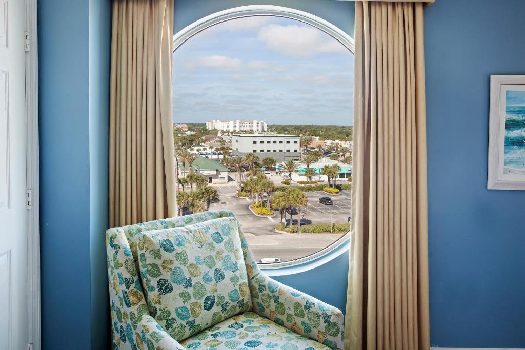una silla en una habitación con ventana en Royal Floridian Resort by Spinnaker, en Ormond Beach
