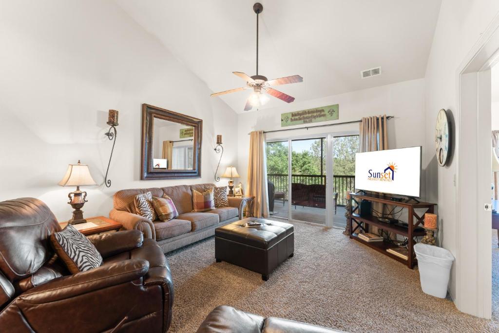 a living room with a couch and a tv at Ozark Comfort Condo in Branson West