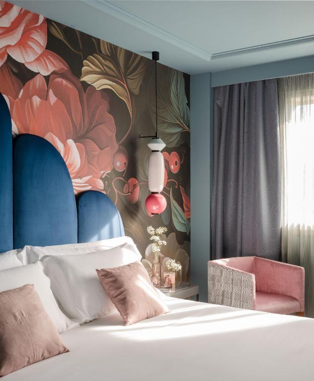a bedroom with a bed and a flower mural at Hotel Antik San Sebastián in Donostia-San Sebastián