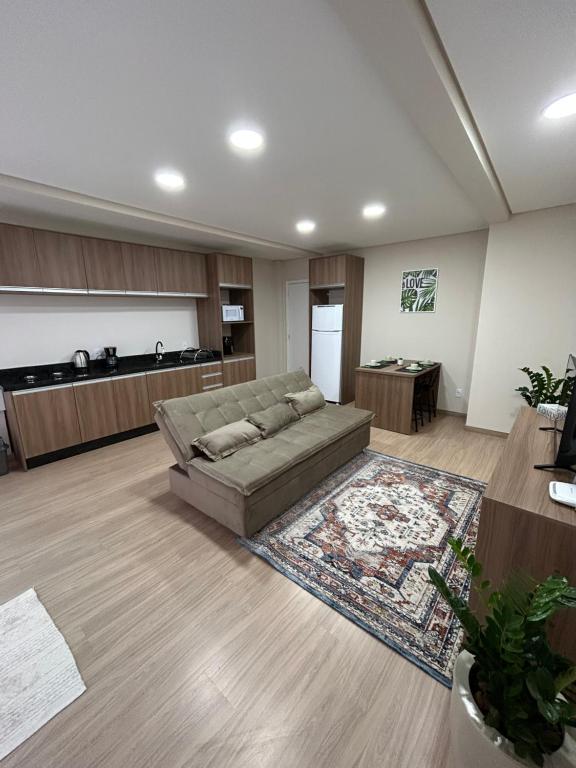 sala de estar con sofá y cocina en Kitnet 5, en Rio Negrinho
