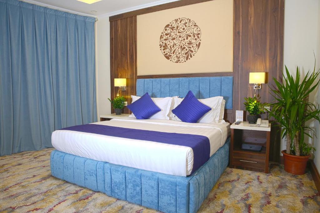 فندق فاندال في جازان: غرفة نوم مع سرير أزرق كبير مع وسائد زرقاء