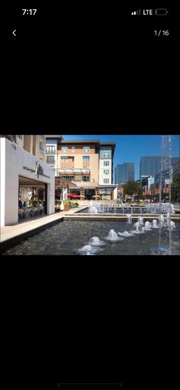 a picture of a fountain in front of a building at Comfy and Cozy Legacy West Apartment steps from everything in Plano