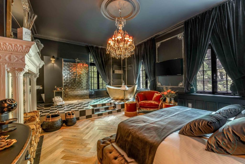 a bedroom with a large bed and a chandelier at Castelsuites in Bruges