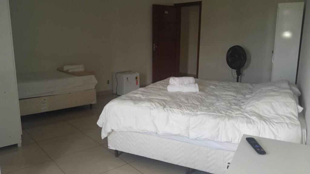 1 dormitorio con 1 cama blanca grande y escritorio en Hotel Santorine Prime - By UP Hotel - Próximo a Fundação Cultural Carlos Drummond Andrade, en Itabira