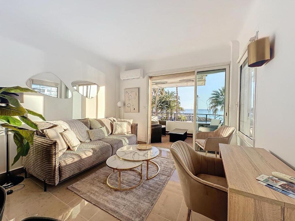 a living room with a couch and a table at Two en-suite bedroom apartment on La Croisette - Sea view in Cannes