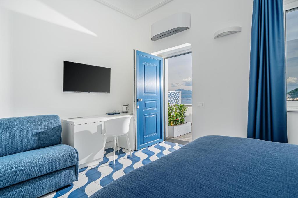 - une chambre avec une porte bleue, un lit et un bureau dans l'établissement Villa Azzurra, à Vico Equense