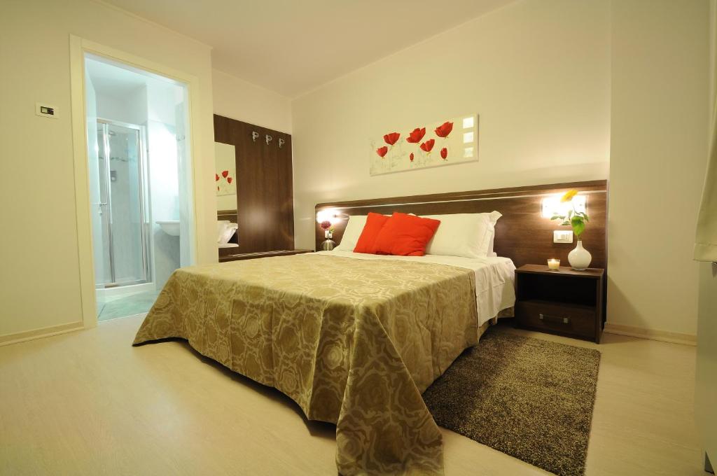 a bedroom with a large bed with red pillows at Albergo Leon Bianco Gonars in Gonàrs