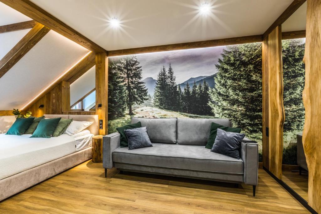 a bedroom with a couch in front of a window at Apartamenty ForRest Krupówki in Zakopane